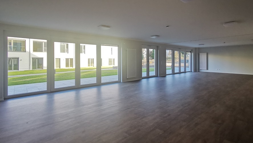 Heller Gemeinschaftsraum mit Zugang zum Garten für Aktivitäten und Veranstaltungen